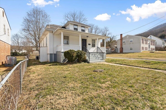 view of front of house featuring a porch, fence, and a front yard