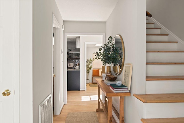 corridor featuring visible vents, light wood-style flooring, and stairway