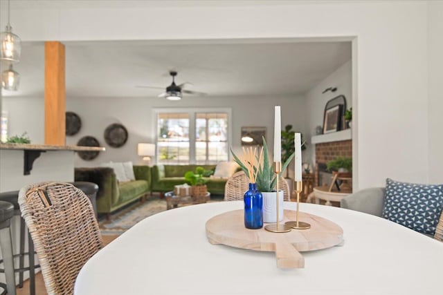 dining space with a fireplace and ceiling fan