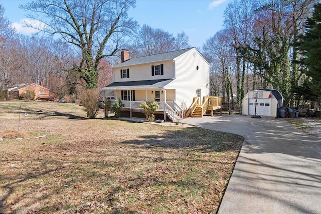 view of front of house with an outbuilding, a front lawn, a porch, roof with shingles, and a chimney