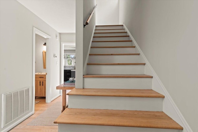 stairs featuring visible vents and wood finished floors