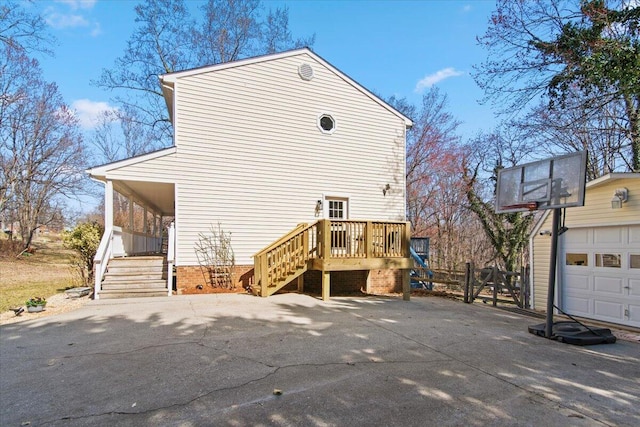 back of property featuring a garage, driveway, and stairway