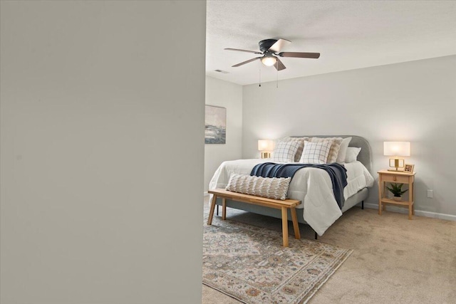 bedroom featuring a ceiling fan, visible vents, baseboards, a textured ceiling, and light carpet