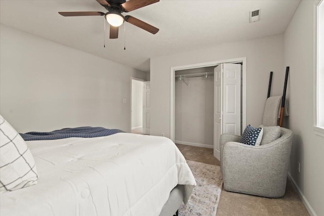 carpeted bedroom featuring baseboards, visible vents, a closet, and ceiling fan