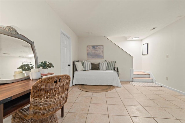 bedroom featuring light tile patterned floors, visible vents, and baseboards