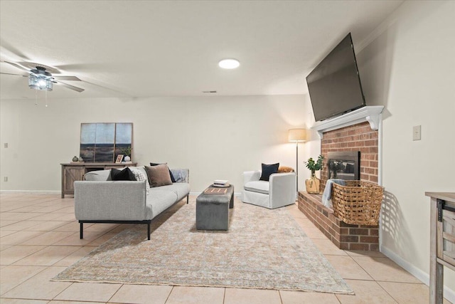 living room featuring visible vents, a brick fireplace, baseboards, light tile patterned flooring, and a ceiling fan