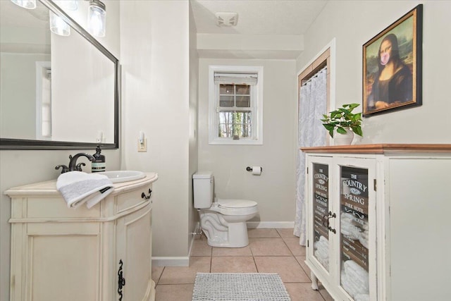 bathroom featuring tile patterned floors, baseboards, toilet, and vanity