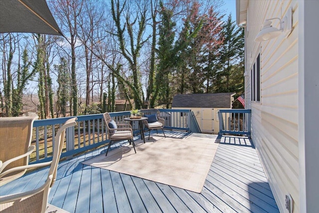 wooden deck with a storage unit and an outdoor structure