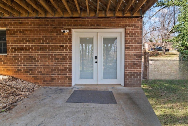 view of exterior entry with french doors and brick siding