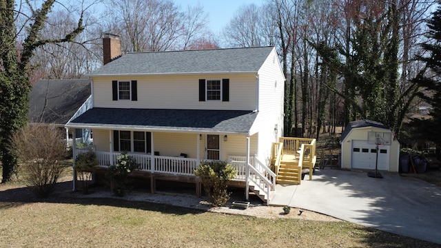 view of front facade with a porch, a shingled roof, a chimney, an outdoor structure, and a garage