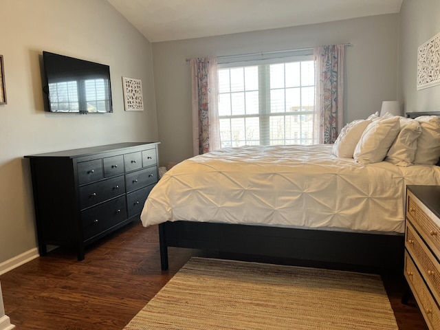 bedroom with dark wood-style floors, baseboards, and vaulted ceiling