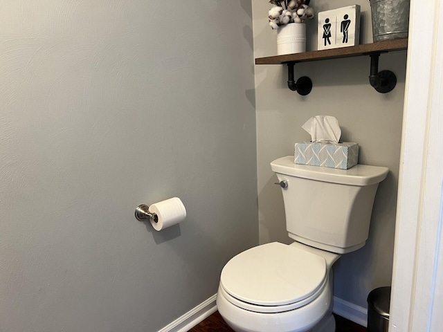 bathroom with baseboards and toilet