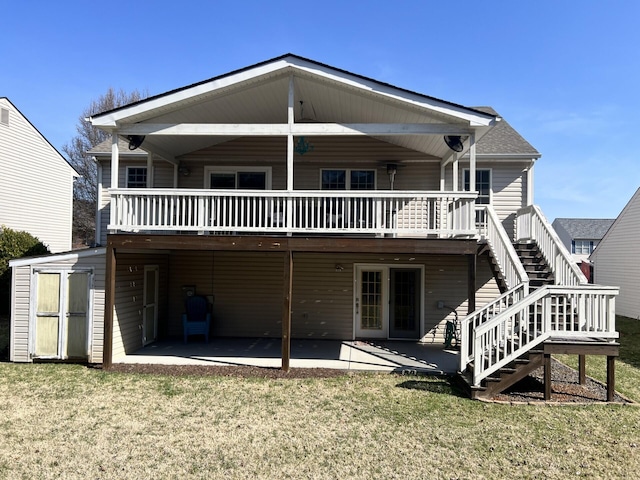 rear view of house featuring stairway, a lawn, a patio, and a deck