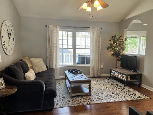 living room with ceiling fan, baseboards, wood finished floors, and vaulted ceiling