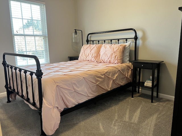 bedroom with baseboards and carpet