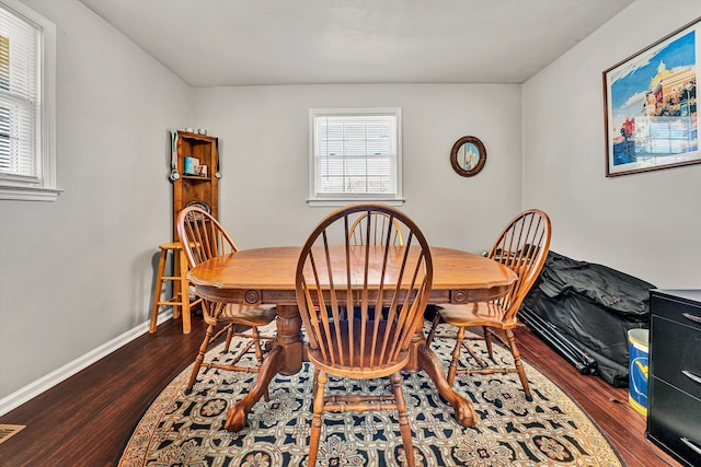 dining area with baseboards and dark wood-style flooring