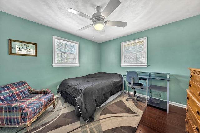 bedroom with a ceiling fan, baseboards, and wood finished floors