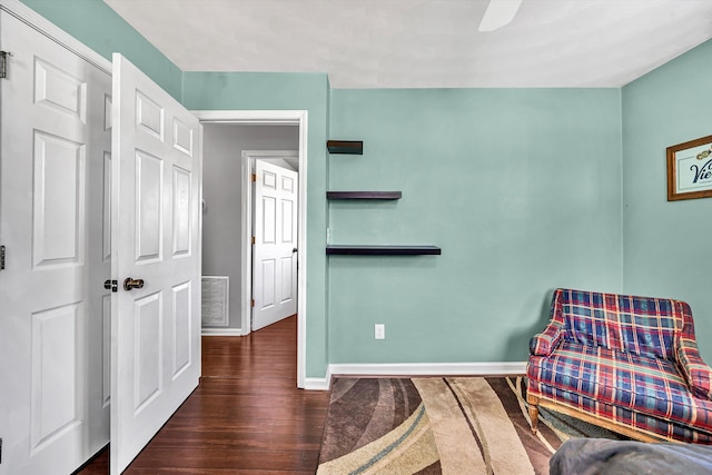 living area featuring visible vents, wood finished floors, and baseboards