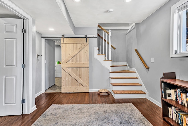 stairway featuring a barn door, recessed lighting, wood finished floors, and baseboards