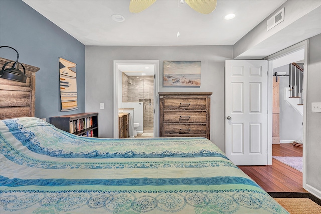 bedroom featuring visible vents, connected bathroom, baseboards, and wood finished floors