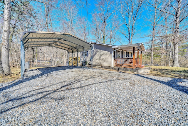 exterior space featuring a detached carport, a porch, and driveway