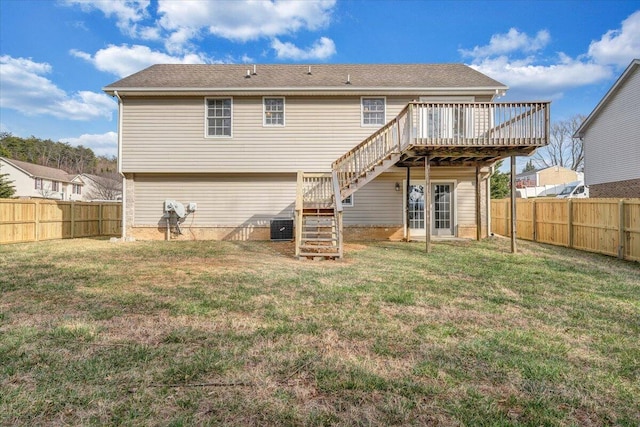 rear view of property with a fenced backyard, a lawn, a deck, and stairs