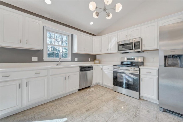 kitchen with a sink, lofted ceiling, white cabinets, and stainless steel appliances