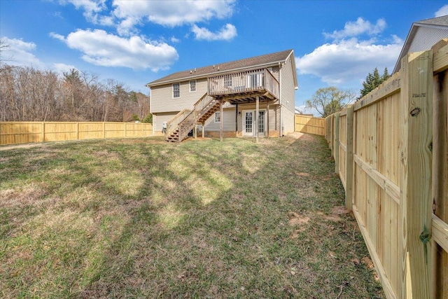 rear view of house featuring stairway, a yard, a fenced backyard, french doors, and a deck