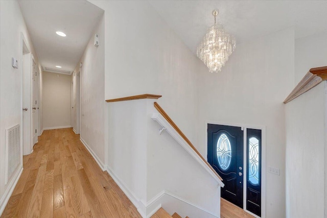 entrance foyer with visible vents, wood finished floors, recessed lighting, an inviting chandelier, and baseboards