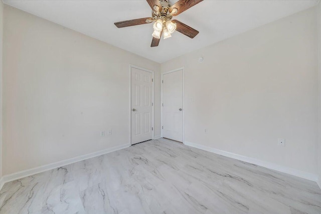 empty room with a ceiling fan and baseboards