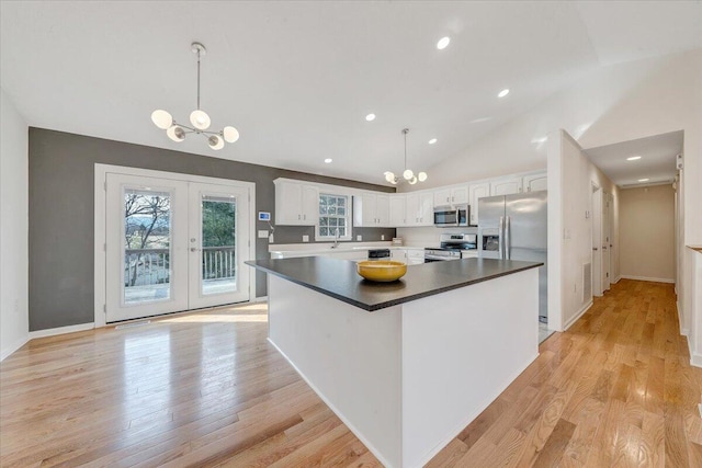 kitchen with light wood-type flooring, a sink, french doors, appliances with stainless steel finishes, and white cabinets