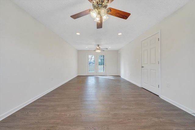 empty room with baseboards, a textured ceiling, and wood finished floors