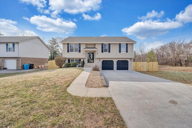 split foyer home with a front yard, an attached garage, fence, and driveway