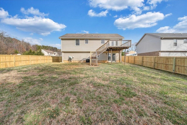 back of property with a lawn, a wooden deck, stairs, and a fenced backyard