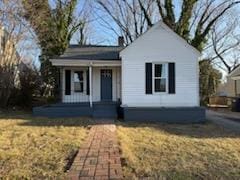 view of front of house with covered porch and a front lawn