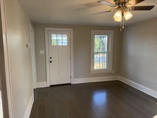 entryway featuring a ceiling fan, baseboards, and dark wood-style flooring