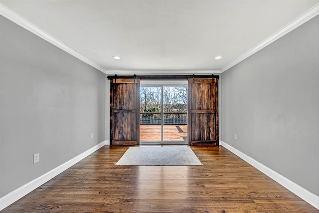 unfurnished room featuring a barn door, baseboards, dark wood finished floors, and crown molding