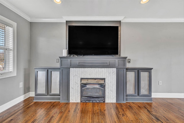 room details with wood finished floors, recessed lighting, a fireplace, crown molding, and baseboards