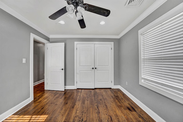 unfurnished bedroom with visible vents, baseboards, dark wood finished floors, ceiling fan, and ornamental molding