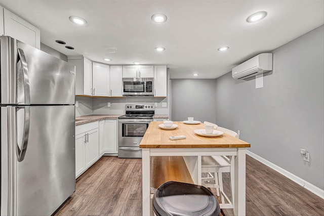 kitchen featuring stainless steel appliances, white cabinetry, butcher block countertops, and a wall unit AC