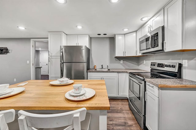 kitchen featuring a sink, dark wood-style floors, white cabinetry, recessed lighting, and stainless steel appliances