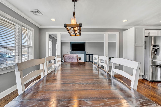 dining space with a chandelier, visible vents, crown molding, and dark wood-style flooring