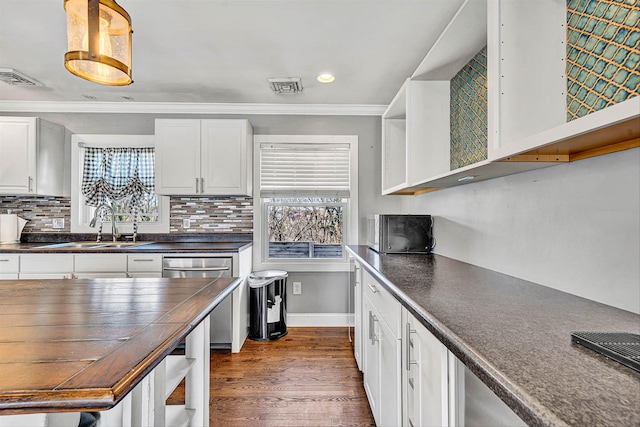 kitchen featuring a sink, backsplash, dishwasher, and open shelves