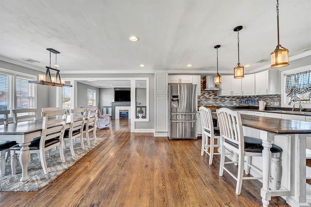 dining space with visible vents, ornamental molding, dark wood-style floors, recessed lighting, and a fireplace