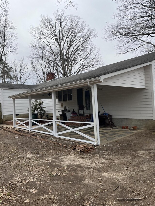 back of house featuring a chimney