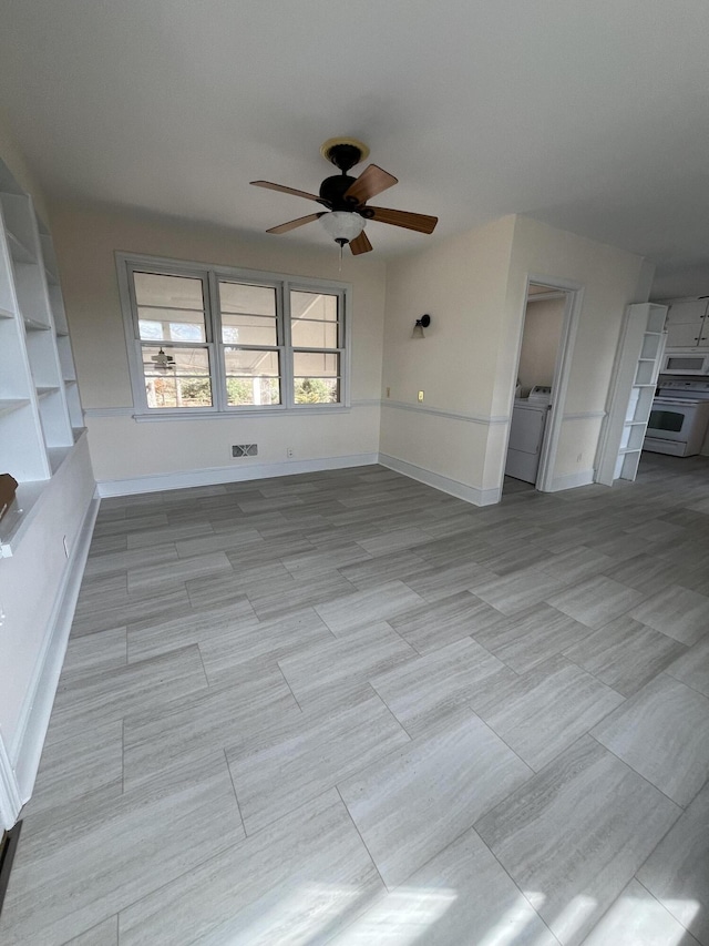 unfurnished living room with baseboards, washer / clothes dryer, and ceiling fan