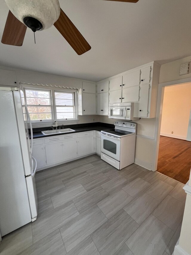 kitchen with ceiling fan, white appliances, white cabinets, and a sink