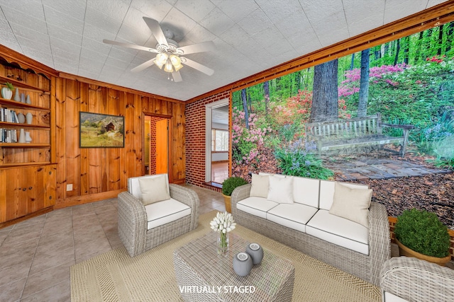 tiled living room with built in shelves, a ceiling fan, and wood walls