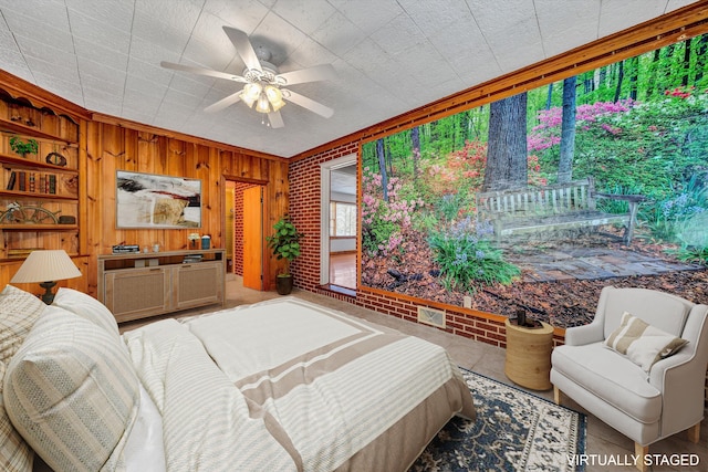 bedroom featuring wooden walls, a ceiling fan, and brick wall