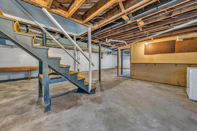 unfinished basement with stairway and washer / dryer